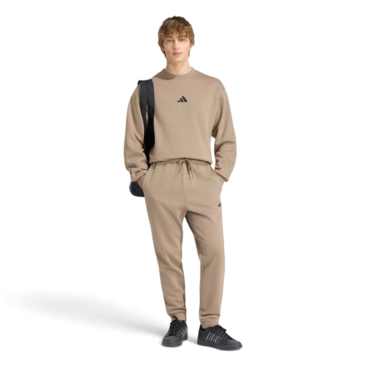 Pantalon Adidas Essentials Feelcozy Fleece pour hommes, kaki, porté en pied avec cordon à la taille