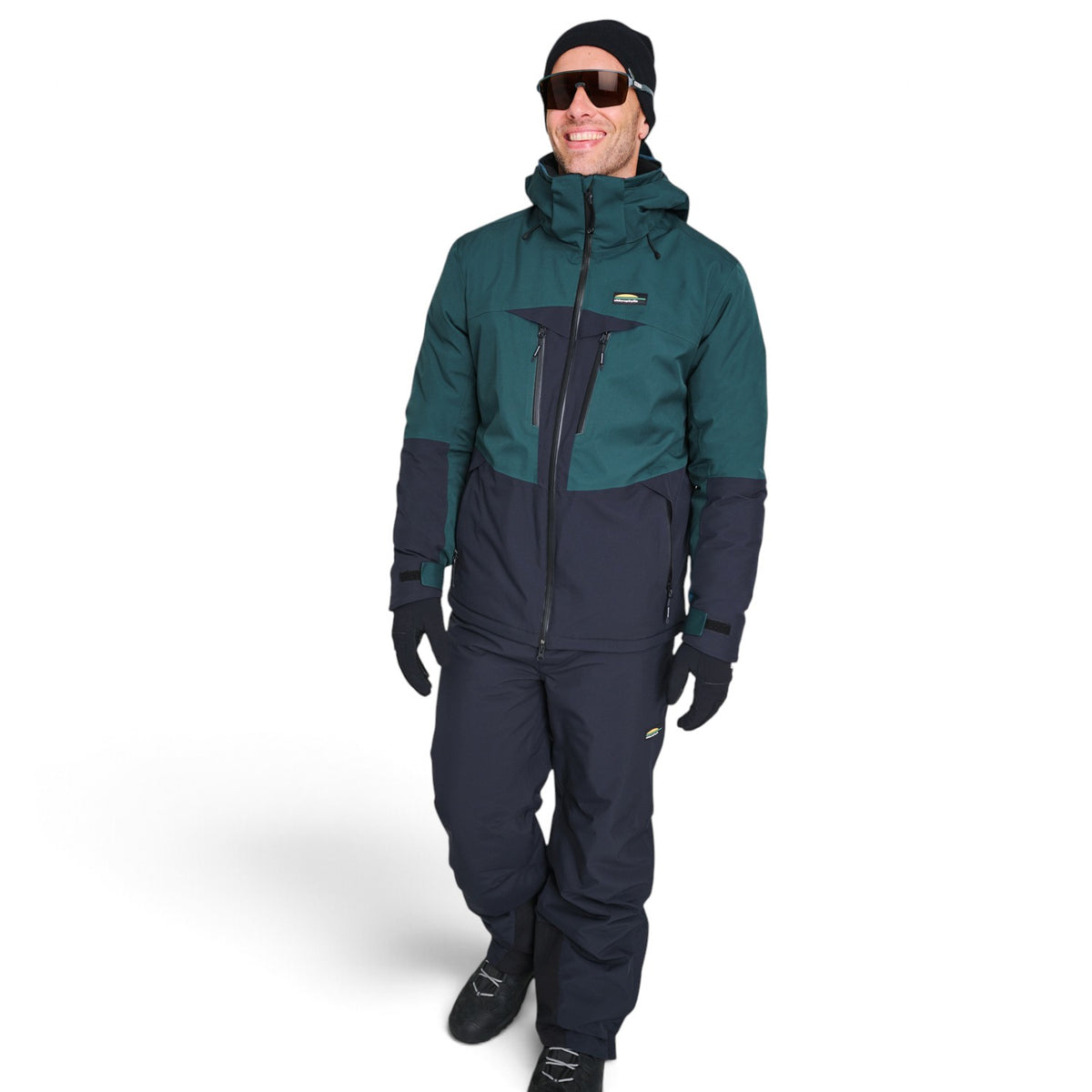 Homme portant le pantalon de ski Chlorophylle ORCA avec un manteau d'hiver, vue de face
