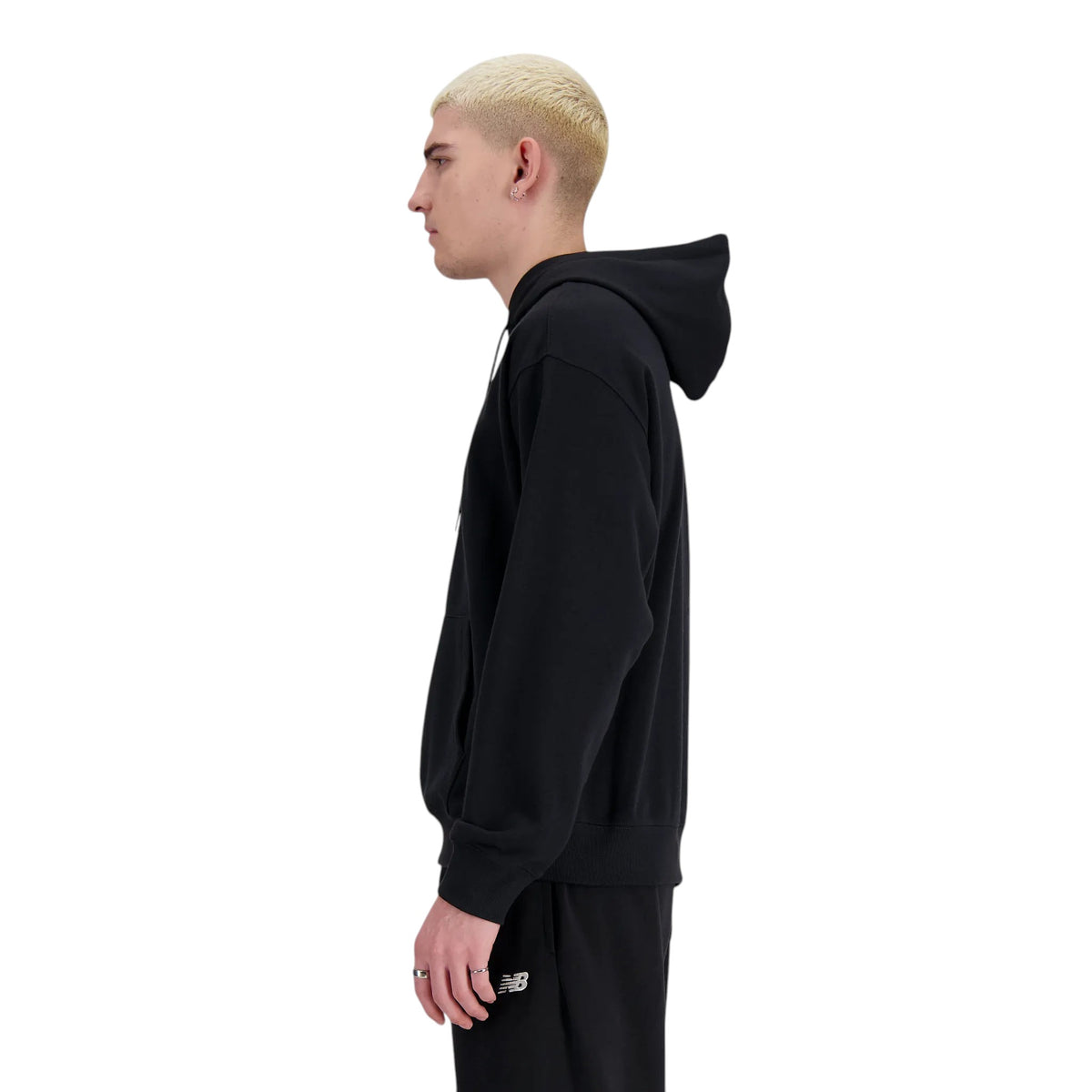 Homme de profil portant le coton ouaté à capuchon New Balance Sport Essentials noir