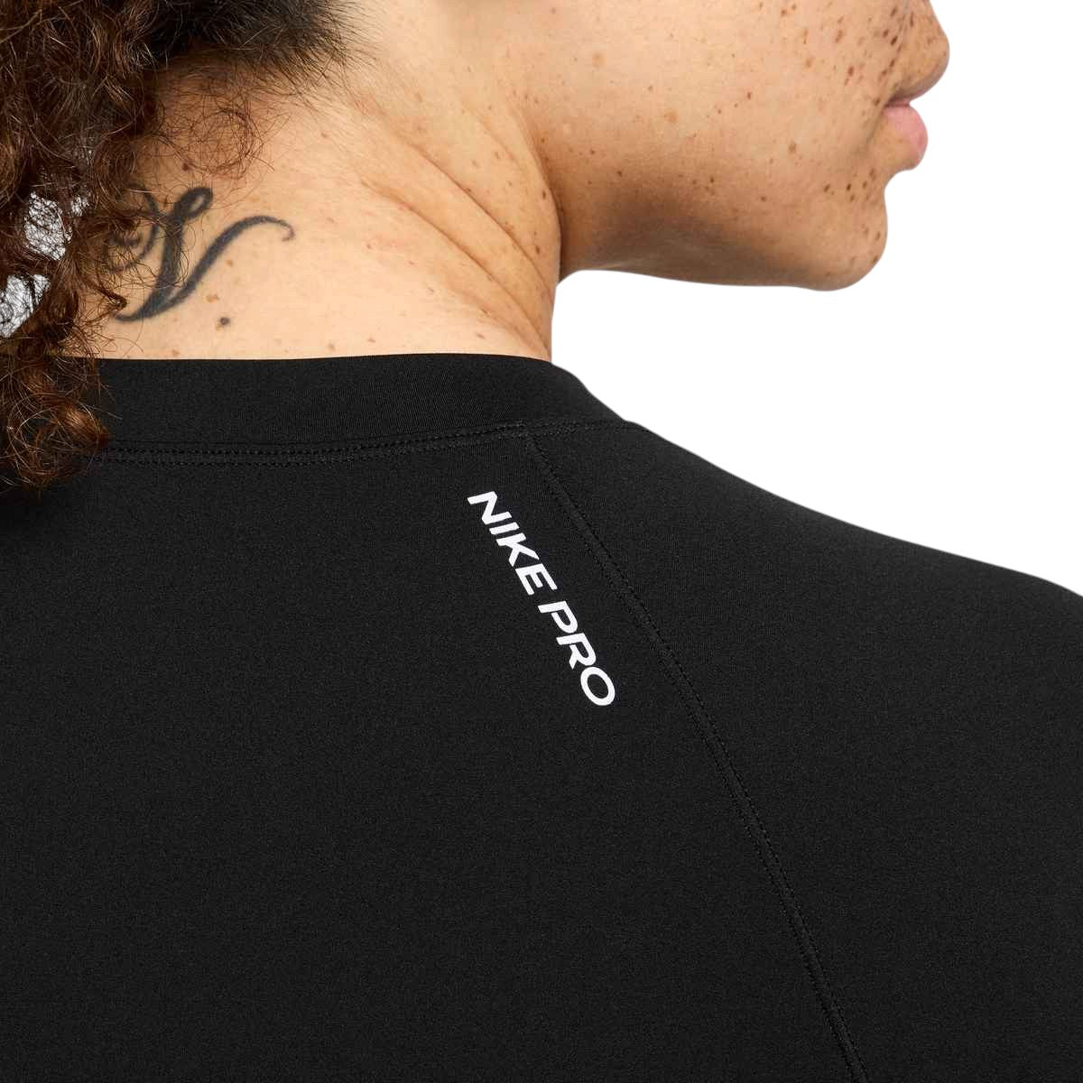 Chandail à manches longues Nike Pro noir pour femmes, détail de l'inscription NIKE PRO au dos du col