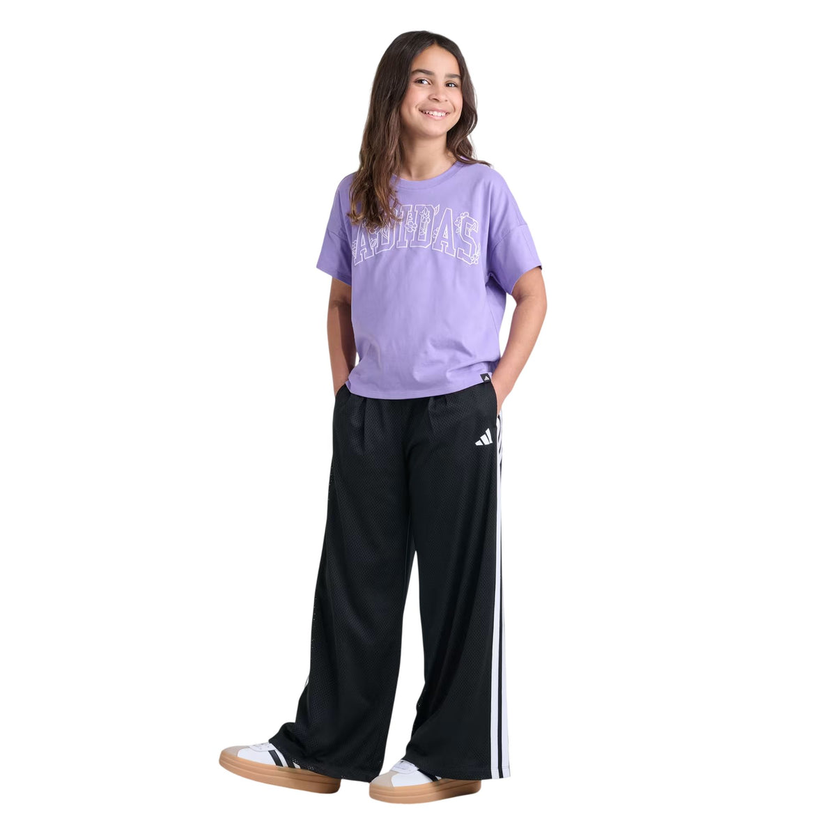 Fille portant le T-shirt Adidas lilas à logo Adidas floral avec pantalon noir à bandes, vue d'ensemble