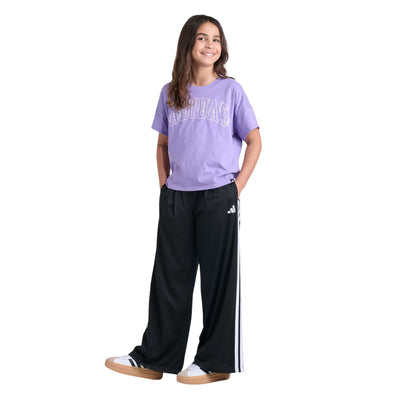 Fille portant le T-shirt Adidas lilas à logo Adidas floral avec pantalon noir à bandes, vue d'ensemble