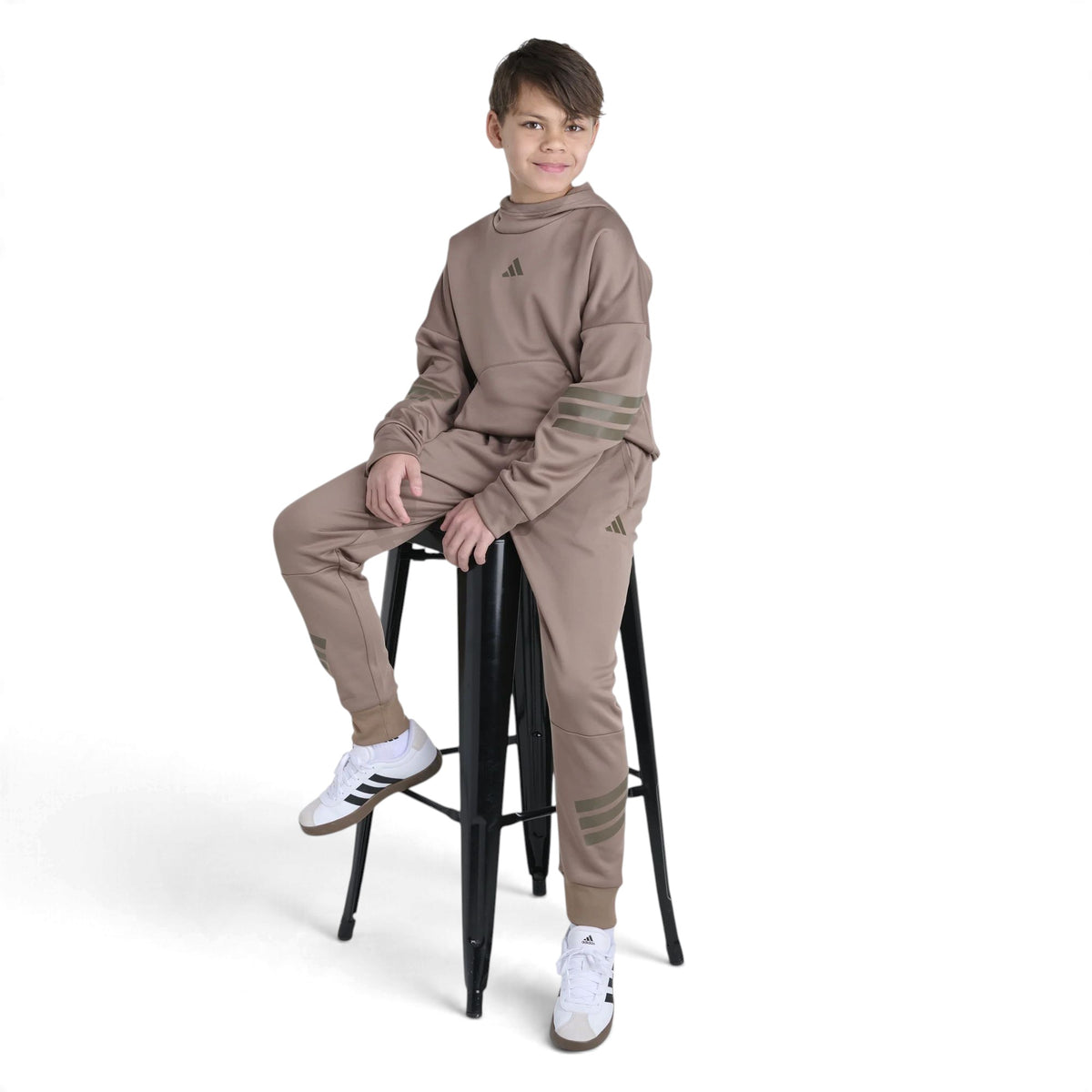 Chandail à capuchon Adidas Future Icons pour garçons porté assis avec un pantalon jogger, vue de face