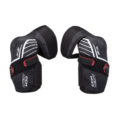 Coudières de hockey CCM Next 26 pour juniors, noir, paire avec coquille JDP cap, logo CCM NEXT et courroies à velcro
