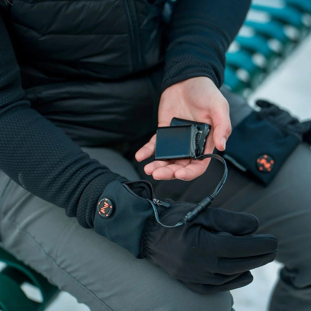Sous-gant chauffant Fieldsheer noir porté pour adultes, bloc-batterie tenu dans la main