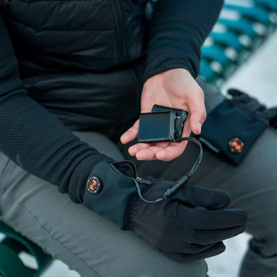 Sous-gant chauffant Fieldsheer noir porté pour adultes, bloc-batterie tenu dans la main
