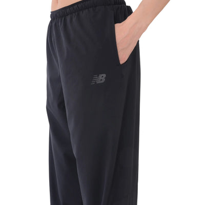 Gros plan sur la poche latérale et le logo New Balance du pantalon de jogging noir pour femmes